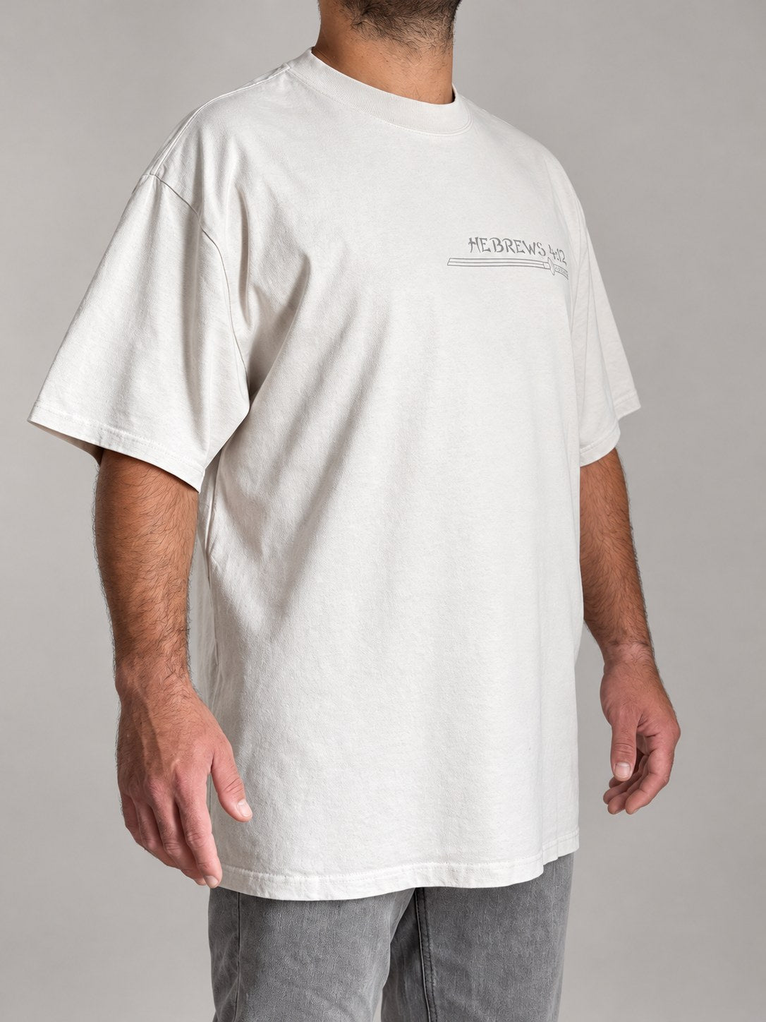 Hebrews 4:12 tee in Faded Bone, three-quarter view on a male model with the katana chest print