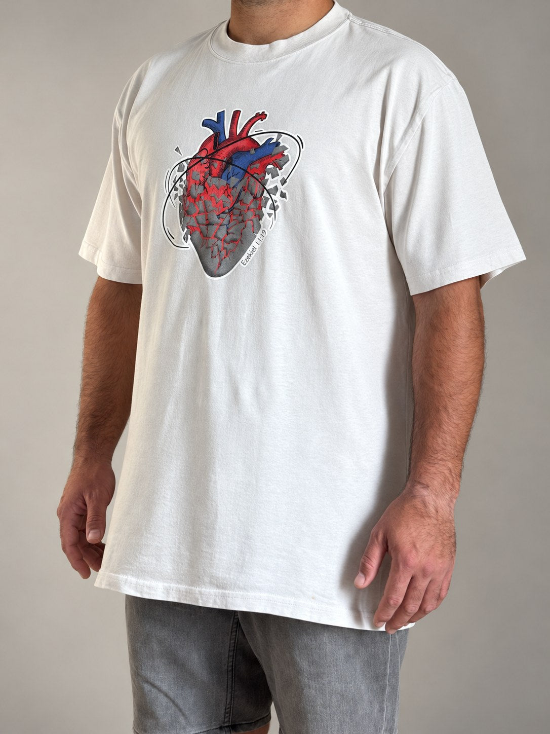 Ezekiel 11:19 tee in Faded Bone, three-quarter view of the boxy oversized fit on a male model