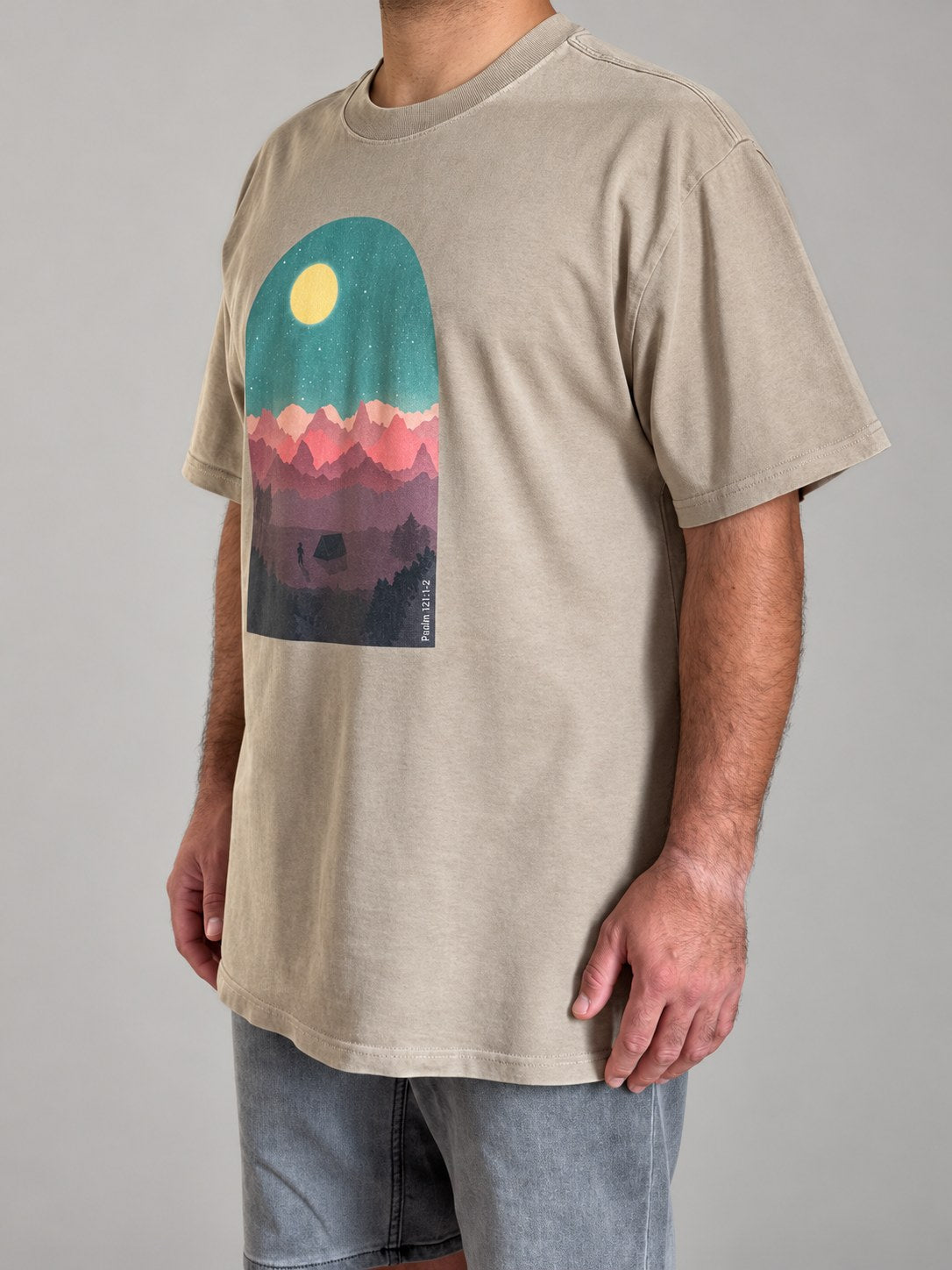 Psalm 121:1-2 tee in Faded Khaki, side angle on a male model with the dropped shoulders and mountain print
